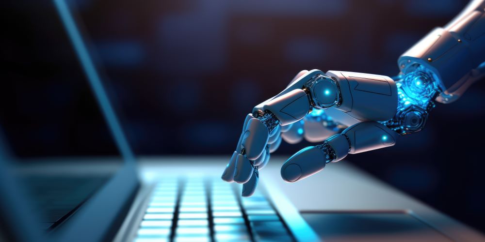 A robot hand typing on a laptop